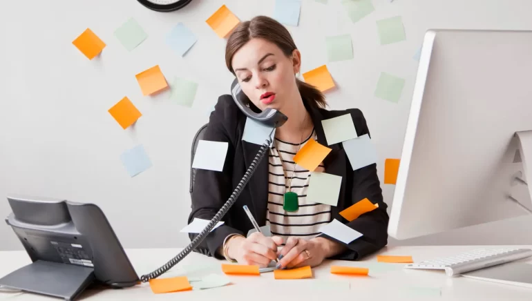 Studio shot of young woman working in office covered with adhesive notes